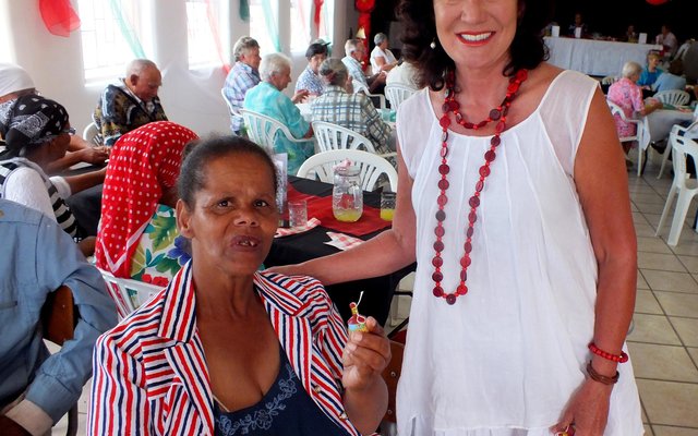 Rdl Riana de Coning is hier besig om die Kersklappers aan die bejaardes uit te deel, met Alida Wildschut wat hare ontvang  